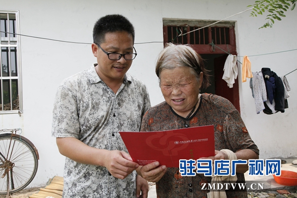 媽媽拿著兒子大紅色的大學(xué)錄取通知書(shū)，心里很美。.jpg