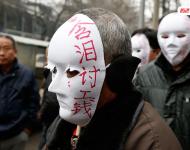 近幾年，由于經(jīng)濟增速下行，中西部地區(qū)和中小城市成為當前討薪矛盾多發(fā)地區(qū)。一邊是國家和地方維護打工者權益的法律法規(guī)不斷出臺，另一邊則是“年年干活年年欠，年年討薪年年難”。不少打工者不得已只好采取行為藝術等手段以博取關注。圖為2015年2月2日，西安市尚德路陜西省水利廳的門前，七八位頭戴著白色面具者站在凜凜寒風中，面具上寫著：“含淚討工錢” “無顏見父母”等標語。據(jù)了解，這幾個人是70名農(nóng)民工的代表，他們之前在武功縣干的工程被欠款156萬元。誰知，包工頭不但電話打不通，以前的家也搬了，根本找不到人，多次找到水