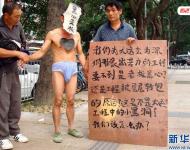 2011年11月22日，深圳福田區(qū)東園路上，河南籍農(nóng)民工韓文德雇人頭戴“黑心老板”面具，只穿一條內(nèi)褲走在街上，這么做是為了討要承包方欠下的21萬元工錢。他表示，自己和13名老鄉(xiāng)去年底參與深圳某大廈外墻翻新工程，今年8月完工后沒拿到應得的工資，希望這樣的方式能引起有關方面的重視。經(jīng)記者調(diào)查發(fā)現(xiàn)，勞資雙方的合同沒有文字憑據(jù)，成了一筆死無對證的“糊涂賬”。新華社發(fā)